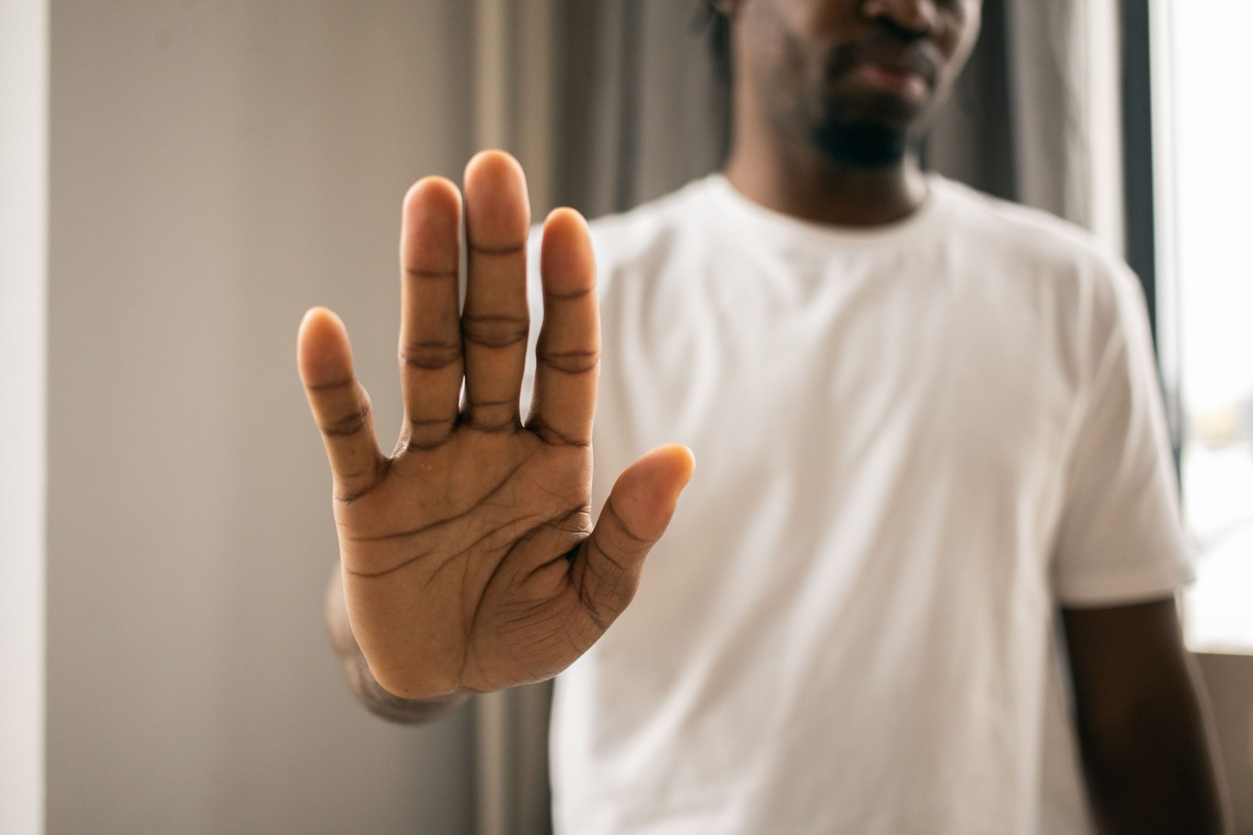 Actor using a stop gesture to represent rejection.