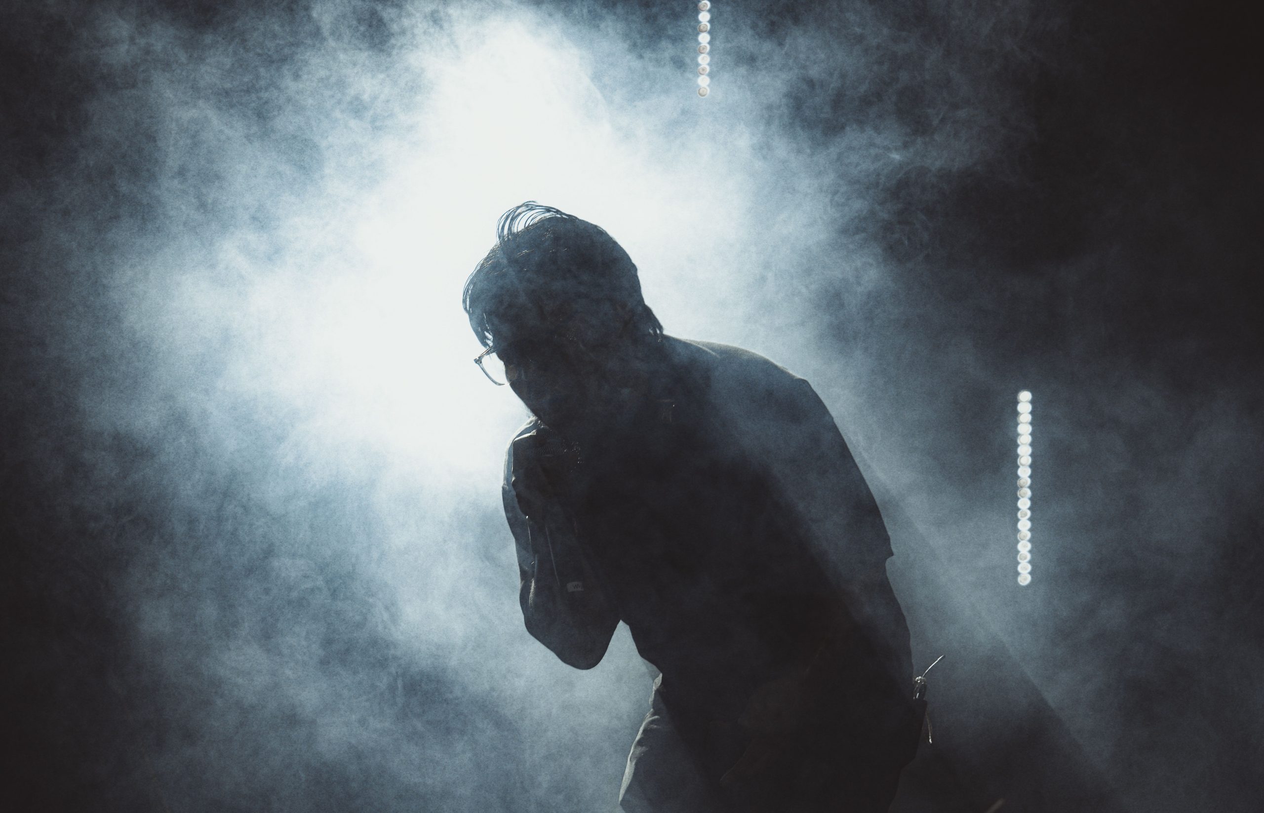 Performer on a smoky stage experiencing the pressure of performing in front of an audience.