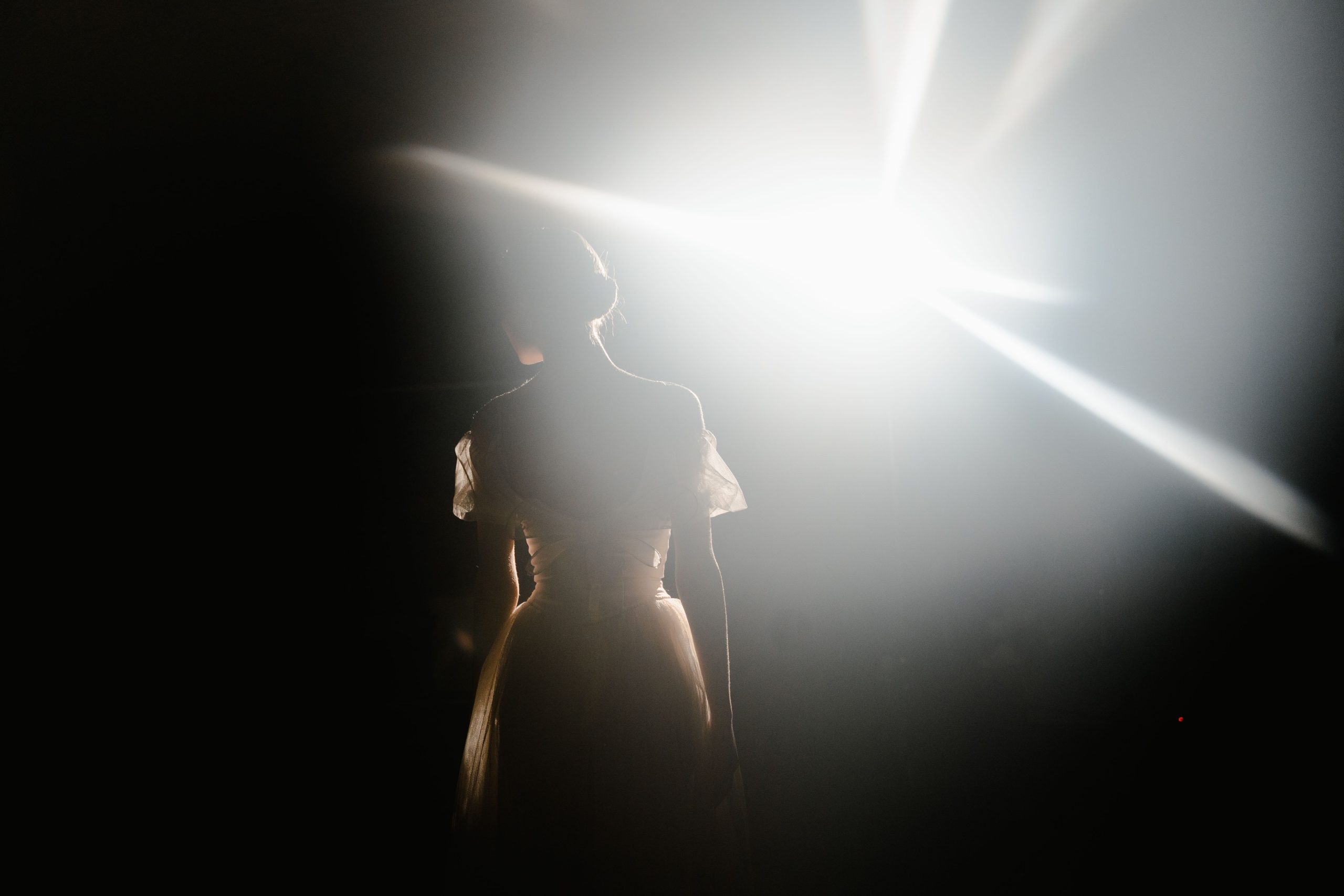 An actor standing alone under a spotlight, symbolizing performance and excellence in acting.