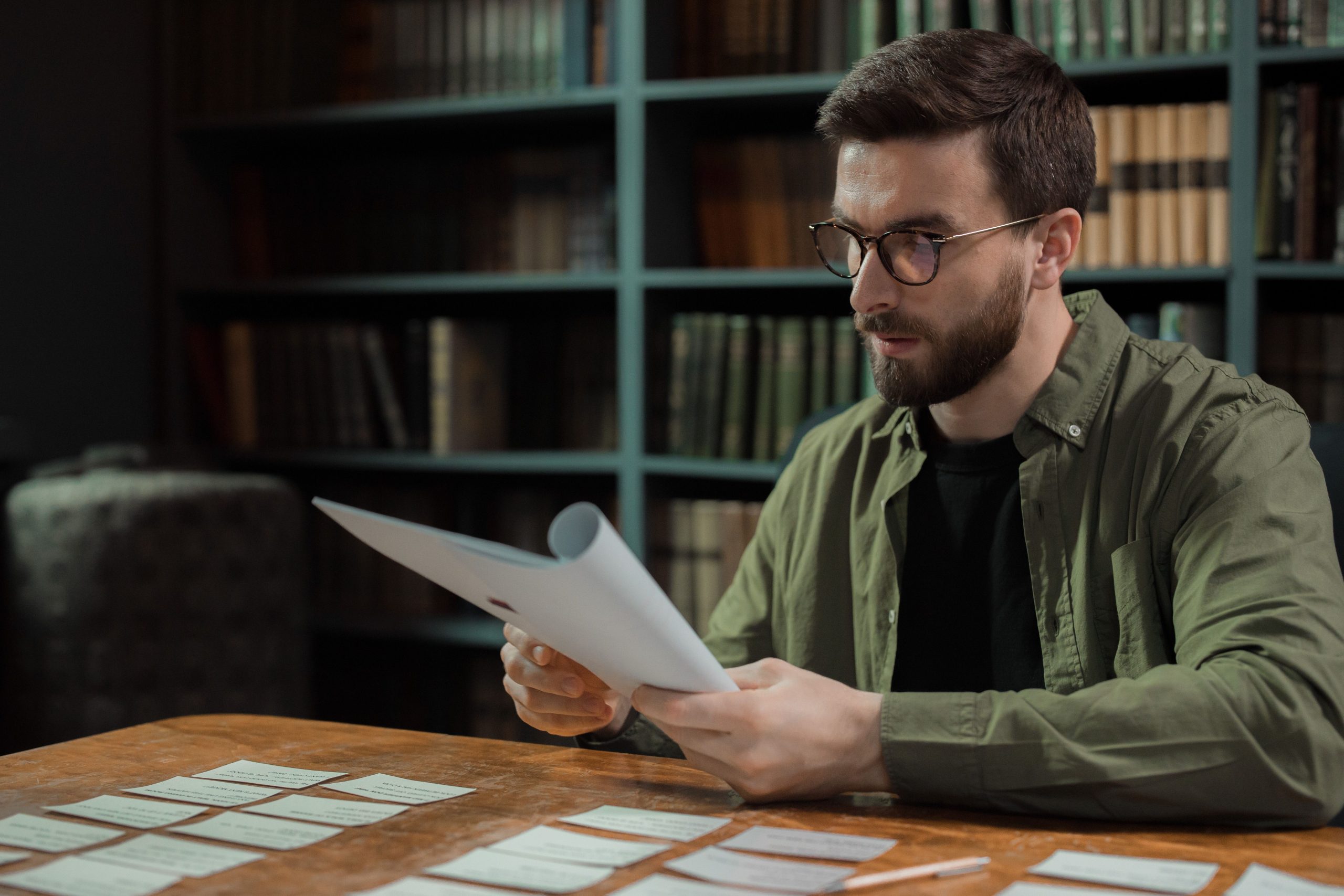 Actor reviewing paperwork and script notes while preparing for a monologue.
