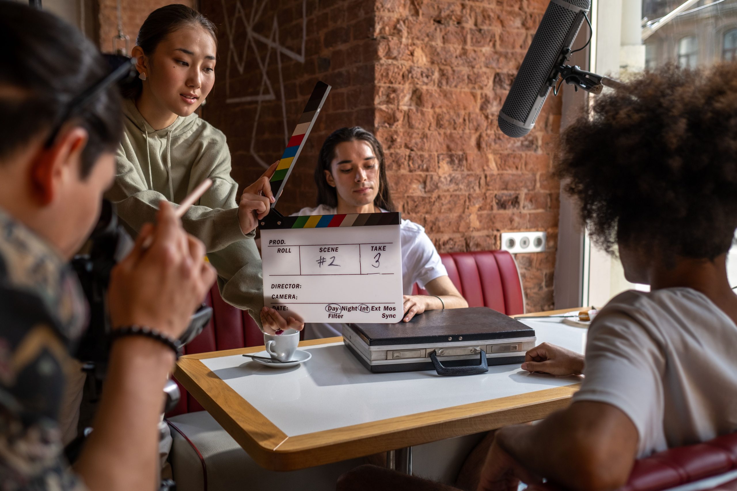 Woman holding a clapperboard while standing on a film set, representing the start of an acting career.