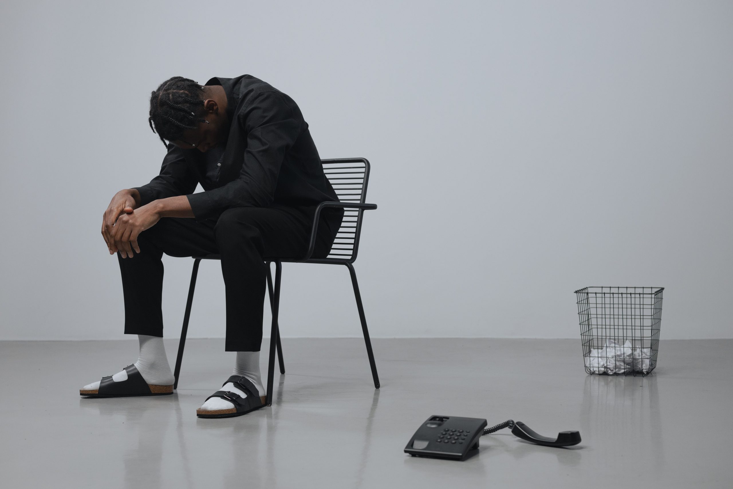 Disappointed actor sitting alone after receiving a rejection call.